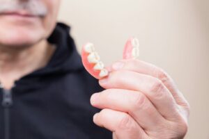 person in black hoodie holding white candy